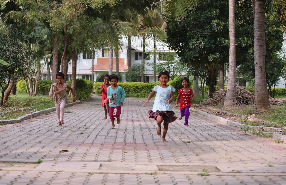 Children running and playing on the Prema Jyothi campus pathway