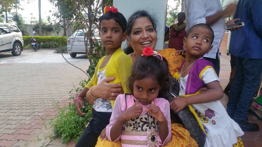 A visitor with children at Prema Jyothi